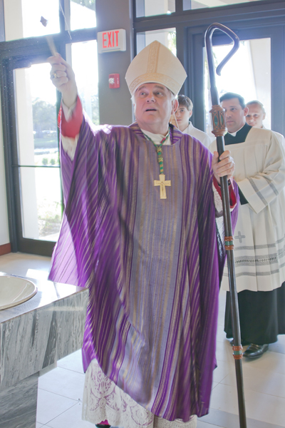 Archbishop Thomas Wenski blesses with Holy water the new entrance and church expansion to St. Henry Catholic Church in Pompano Beach.