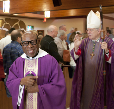 Father Francis A. Akwue, pastor at St. Henry Catholic Church in Pompano Beach, exits the church in procession after a Mass celebrating 45 years since the establishment of the parish and 40 years since the building of the current church.