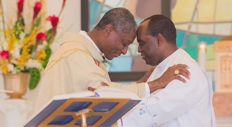 Cardinal Chibly Langlois and Father Reginald Jean-Marie, administrator of Notre Dame d'Haiti Mission, share a sign of peace during Mass.