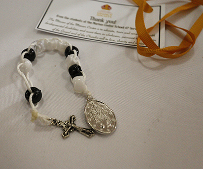 Aside from a lapel pin, Archbishop Coleman Carroll Legacy Society members received a gift hand-crafted by the students of the Marian Center for the developmentally disabled: St. Theresa's sacrifice beads, a reminder to the wearer to do 10 good deeds a day.
