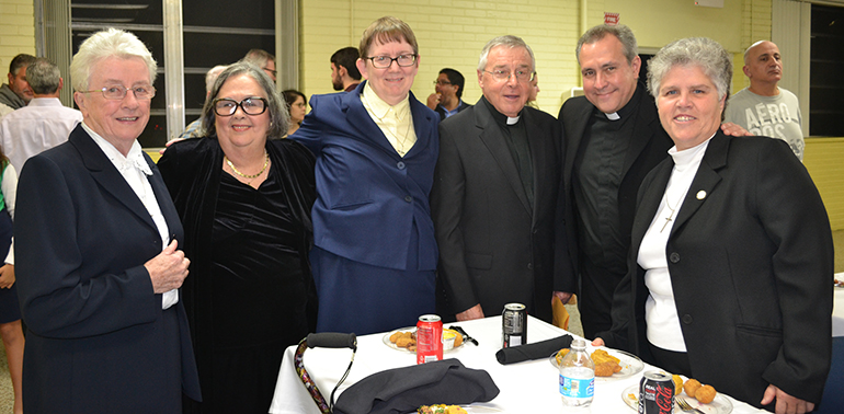 Posing for a photo after the Mass, from left: Sister Margaret Mary Lyons, a former teacher at Sts. Peter and Paul School, Carlota Morales, current principal, Sister Mary Kuester, also a former teacher at the school, Father Juan Lopez, pastor, Father Jose Alvarez, who is both an alumnus and former teacher at the school, and Sister Rosa Lopez, a graduate of the school who entered the Sisters of St. Joseph of St. Augustine after graduation.