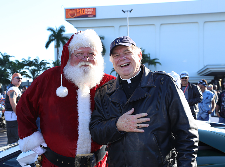 Santa Ed and Archbishop Thomas Wenski pose for a photo before the ride begins.