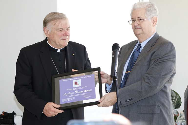 El Arzobispo Thomas Wenski recibe su premio de manos de Pedro González, presidente de la Asociación de Periodistas Hispanos de la Florida.