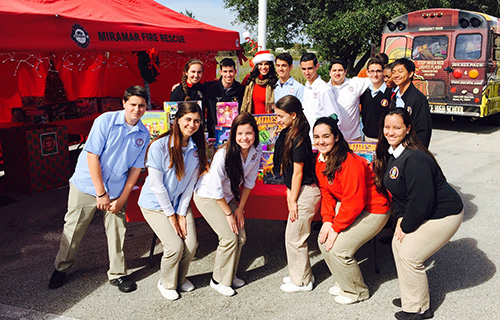Student government representatives from Msgr. Edward Pace High School pose with Pace alumna and Six In The Mix anchor Roxanne Vargas after delivering some 500 toys to the Caravan of Joy collection outside the NBC6 studios in Miramar.