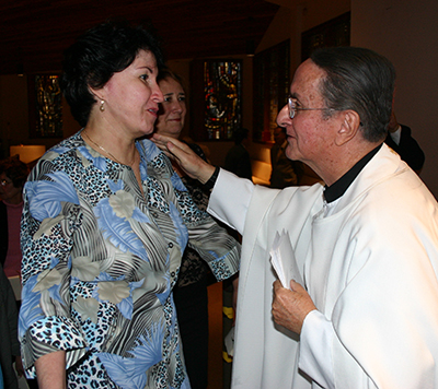 Father Ernesto Molano greets an archdiocesan co-worker during a 2006 Mass in honor of his 50th anniversary as a priest.