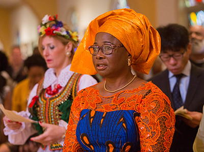 Oby Okany of Nigeria and Joanna Cieslak of Poland pray during the annual Mass celebrating cultural diversity in the archdiocese.