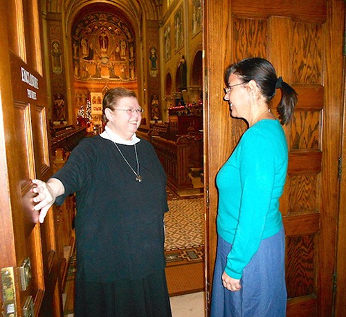 Sister Dawn Annette Mills, left, prioress general of the Benedictine Sisters of Perpetual Adoration, opens the Adoration Chapel door to Magali Garcia. Garcia's knock on the door served as a symbol of her desire to enter the congregation of contemplative monastics in Clyde, Mo. Garcia is a member of the St. Louis Parish in Pinecrest.