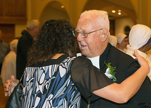 Marist Brother Norbert Rodrigue, celebrating 75 years of religious life, receives a hug from Ileana Roque, administrative assistant in the Office for Religious.