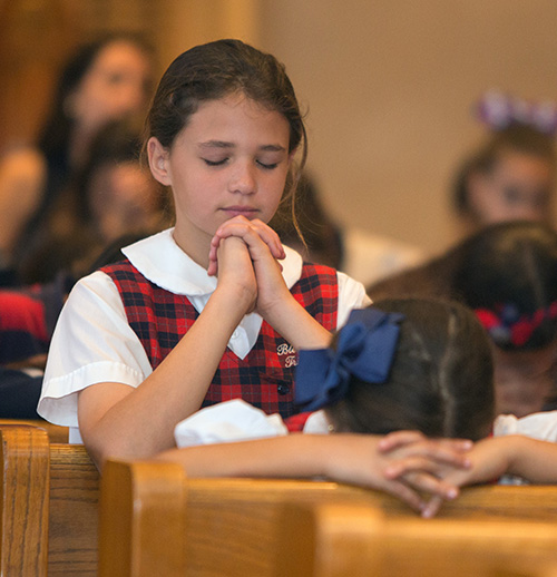 Fourth grader Mary Scheuerle, 10, prays during exposition of the Blessed Sacrament.
