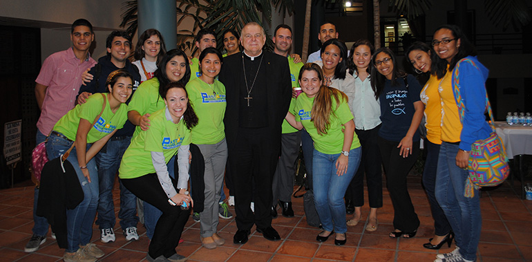 Members of the Pastoral Hispana Juvenil pose with Archbishop Thomas Wenski. They led the music during the adoration that followed the archbishop's reflection.