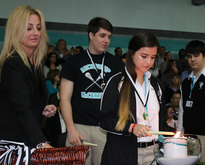 Michelle Maronhic, a junior at Archbishop Edward McCarthy High School, lights a candle during the inaugural Excelsior Scholars Awards.