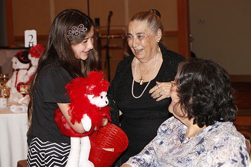 Lucy Petrillo's granddaughter, Alexa Petrillo, her grandmother's best friend, Roseanne Bukowski, get Scarlett, the MACCW Scholarship Committee's "singing mascot" to sing for council members gathered for their 16th annual Scholarship Luncheon.