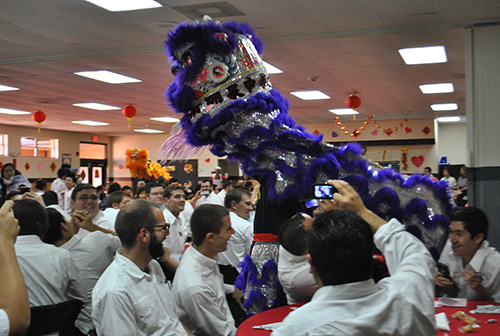 A Chinese lion dances between the tables where seminarians from Saint John Vianney College Seminarians sit.