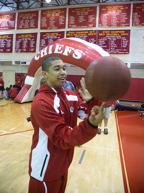 Point guard and senior Jose Morales plays with a basketball at the pep rally celebrating the first state championship for Cardinal Gibbons boys' basketball team.