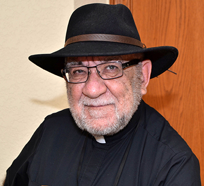 Father Pat Martin poses for a photo after celebrating a Vigil Mass at St. Bonaventure Church, Davie.