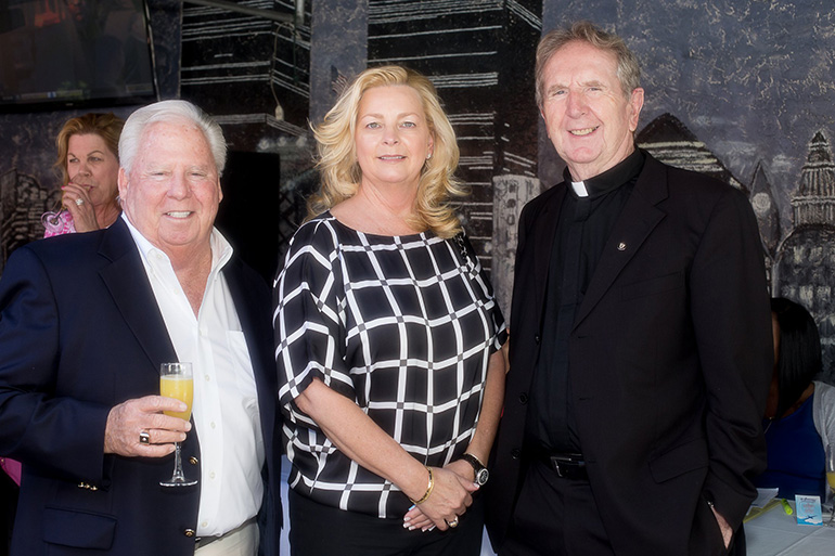 Robert and Lisa Gothier pose with Msgr. William Dever, pastor of St. Paul the Apostle Church, at the Anthony's Runway 84 Cheers to Charity event.