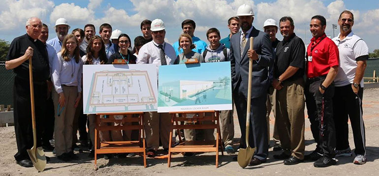 Archbishop Edward A. McCarthy High School students and athletes join Father Brendan Dalton, far left, supervising principal, and Principal Richard P. Jean, fourth from right, as well as coaches, the school's athletic director and the contractor, to participate in the March 19 feast day of St. Joseph groundbreaking for a 5,000 square foot locker room facility.
