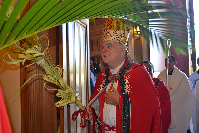 Archbishop Thomas Wenski processes into St. Mary Cathedral on Palm Sunday.