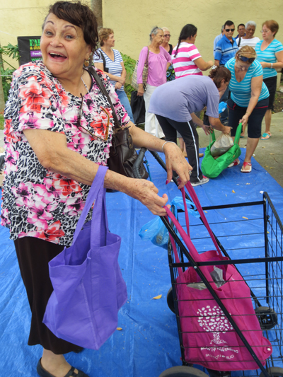 Dora Perez, a parishioner at St. Joachim, is all smiles as her cart slowly fills with goods donated by St. Vincent de Paul's new food pantry.