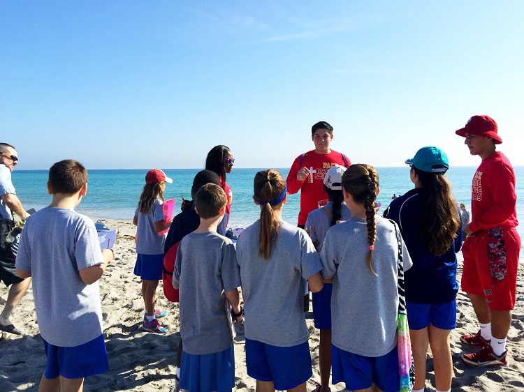 Pace students Keshara Samuels, Brian Rodriguez, and Jonathan Reyes-Diaz (red shirts, left to right) teach a group of Nativity School fifth graders at Hollywood North Beach Park as part of Marine Science Day on Feb. 24.