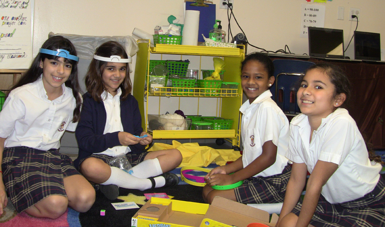 Kiara Lauria, Alexa Montoya, Kissiah Blake and Valeria Garzon are all smiles as they prepare for a round of Hedbanz. Players race to see who can figure out "What am I?" - the illustrated card on their "hedbanz" - by asking questions of their playmates that will provide them with clues to the correct answer.