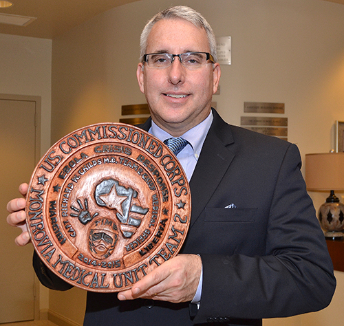 Dr. Richard Childs shows an engraved mahogany plaque he presented to Sister Vivian Gomez, principal of St. Jerome School.