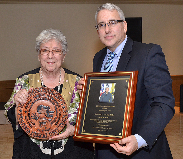 Sister Vivian Gomez and Dr. Richard Childs show the awards they presented each other during a recent dinner-dance for St. Jerome School.
