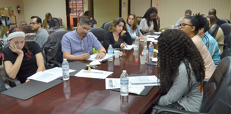 Participants listen to Jan Rayburn as they follow in their workbooks during a Virtus workshop.