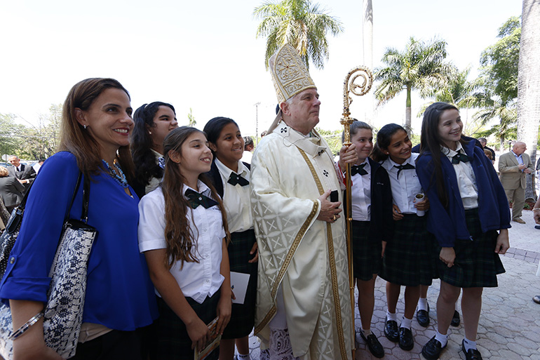 Archbishop Thomas Wenski poses for a photo with students from St. Thomas the Apostle School in Miami. They were among the nearly 250 schoolchildren from 12 schools - 9 high schools and 3 elementary schools - who attended the chrism Mass.