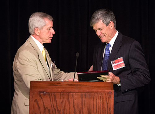 Albert Massey, left, president of the St. Thomas More Society of South Florida, presents the annual Archbishop Edward McCarthy Award posthumously to the Hon. Susan J. Aramony, judge of the 17th Judicial Circuit, Broward County. Nick Kaneldis accepted on her behalf.