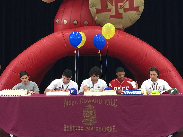 Msgr. Pace High senior student athletes (from left) Christopher Moreno, Eddie and Elliott Cutillas, Lorenzo Hampton, and Damian Alba sign Letters of Intent for universities across the country at a ceremony in the Pace Spartan Center on April 15.