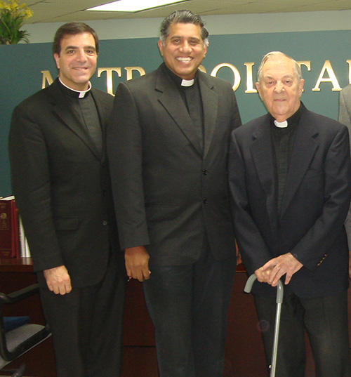 Father Jose Biain, far right, poses on his last day at the Metropolitan Tribunal with fellow staff members, from left: Msgr. Michael Souckar, adjutant judicial vicar, and Msgr. George Puthusseril, judicial vicar.