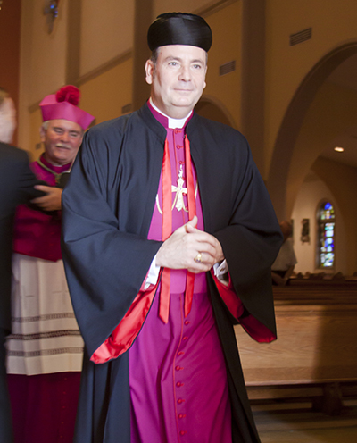 Chorbishop Michael G. Thomas, pastor of Heart of Jesus Maronite Catholic Church in Fort Lauderdale, processes out of St. Mary Cathedral at the end of the prayer vigil for peace in the Middle East.