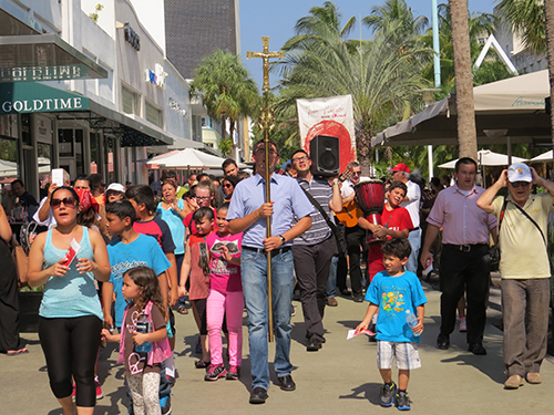 Members of the Neocatechumenal Way carry a cross while singing hymns through the streets of South Beach as part of their annual Easter season street missions in South Florida.