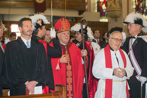 Flanked by the Knights of Columbus, Archbishop Thomas Wenski processes into Gesu Church for annual Red Mass along with Father Eduardo Alvarez, Gesu pastor. Circuit Court Judge Jason Bloch is on the left.