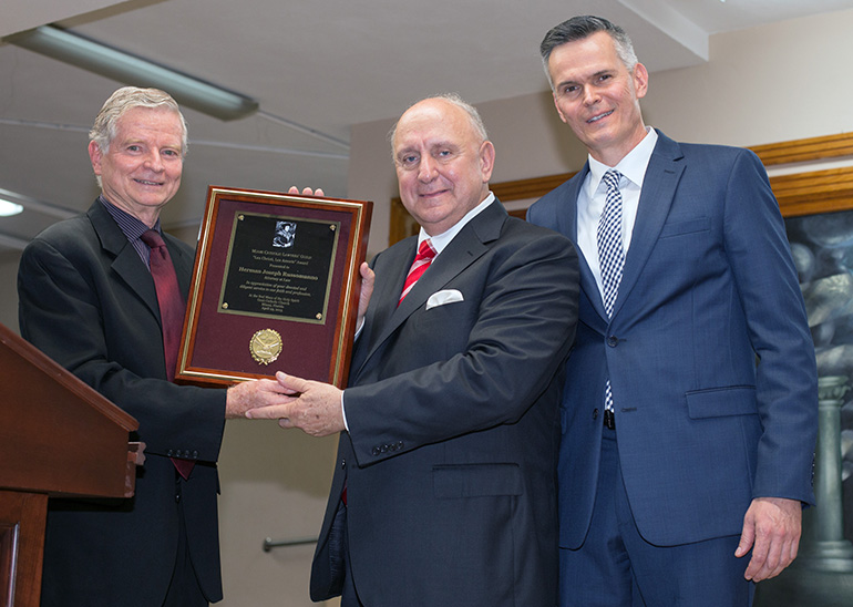 William VanderWyden, left, presents the "Lex Christi, Lex Amoris" award to Herman Russomanno. Standing with them, at right, is William Mulligan, president of the Miami Catholic Lawyers Guild.