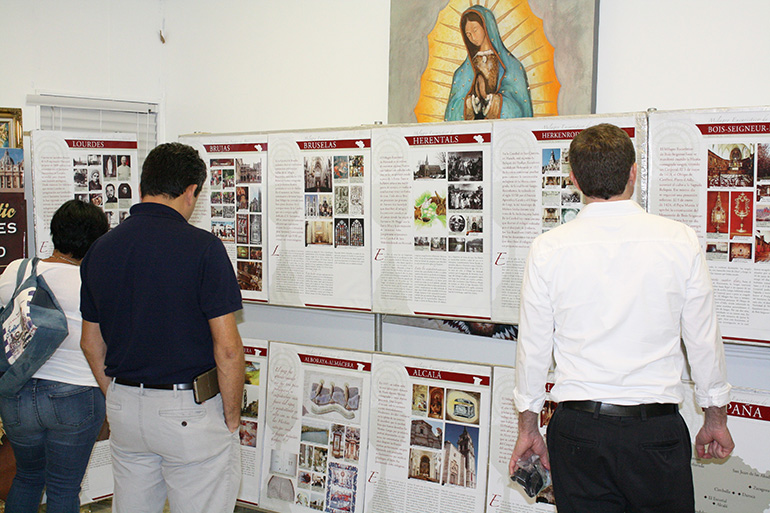 Parishioners and visitors to St. Boniface look over the "Miracles of the Eucharist" exhibit outlining dozens of miracles related to the Eucharist over the centuries, in every corner of the globe.