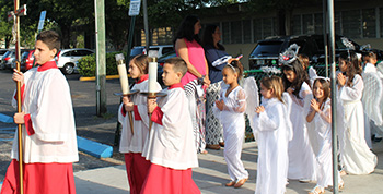 The younger students from St. Kevin School, dressed as angels, process from the school to the church during the May 1 procession and crowning of an image of the Blessed Mother.