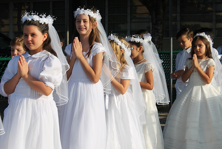Students who were making their first Communion in May process to church during the May crowning at St. Kevin School.