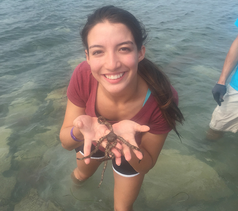 A student in St. Brendan High School's Medical Science Academy shows off one of the specimens she retrieved while tide pooling in the Florida Keys.
