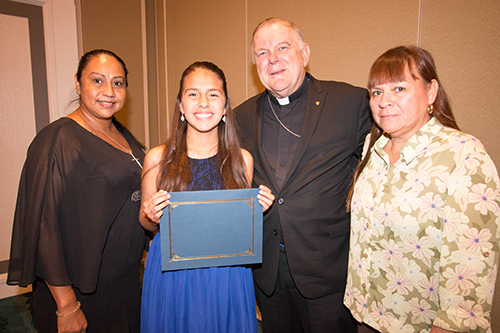 Archbishop Thomas Wenski poses with $ 5,000 scholarship recipient Samantha Ulaje, of St. Louis Covenant School in Pinecrest, and her aunt, left, Leticia Giacalone, and mom, Olivia Ulaje, right.