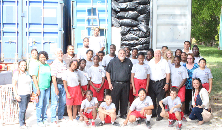 What a team: Our Lady Queen of Martyrs School seventh grade students, teachers, chaperones and San Jose Obrero Foundation volunteers pose after filling one of the trailer containers to capacity. Father Jose Espino, pastor of San Lazaro, is in the center, and Father Alejandro Lopez is standing in the white shirt, third from right in the front row.