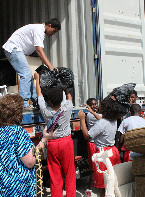 Students hand off one of the last donation bags to a San Jose Obrero Foundation volunteer.