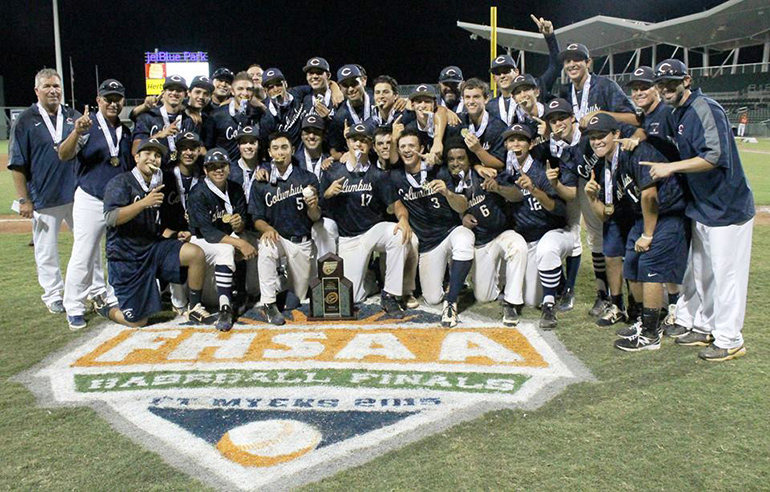 Members of Christopher Columbus High's baseball team pose with their state championship trophy at JetBlue field in Fort Myers.