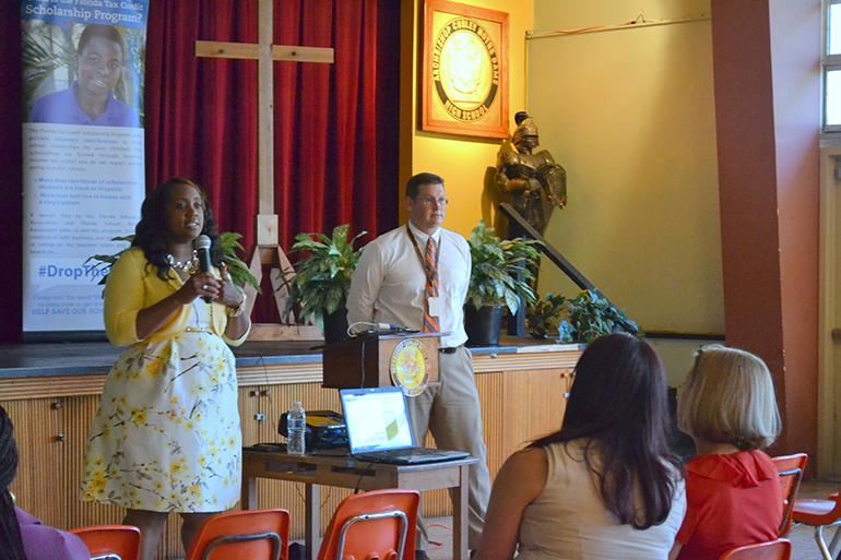 Attendees listen to Marlene Desdunes, an advocate for Step Up and an alumna of St. Mary Cathedral School and Archbishop Curley Notre Dame High School. Desdunes is also a teacher in Miami Dade County Public Schools. Next to her principal Douglas Romanik of Archbishop Curley Notre Dame.