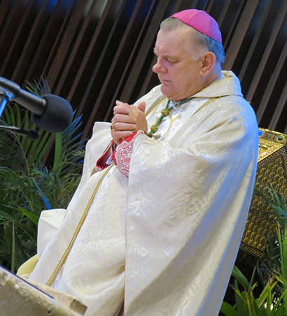 Archbishop Thomas Wenski prays before the Catholic Hospice Memorial Mass held June 20, at St. Hugh Church, in Miami.