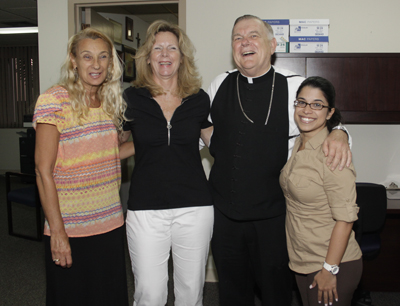 Before getting back to work, Archbishop Thomas Wenski poses with the Safe Environment staff, from left: Myriam Leinweber, Background Check coordinator, Jan Rayburn, Virtus Training coordinator, and Erica Gutierrez, Background Check coordinator.