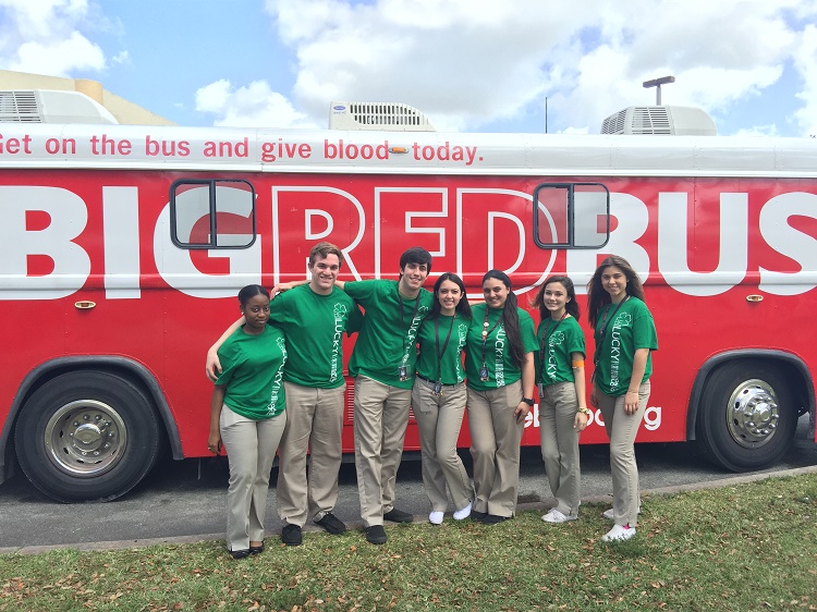 Members of the Msgr. Pace High School Leadership team pose for a photo in front of the One Blood bus during one of the school's quarterly blood drives.