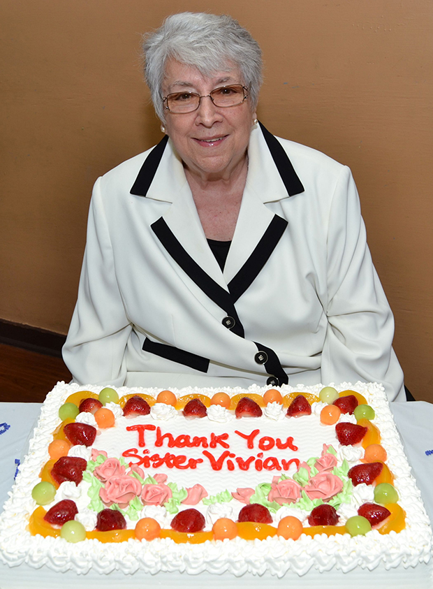 Sister Vivian pauses before cutting a cake in her honor.