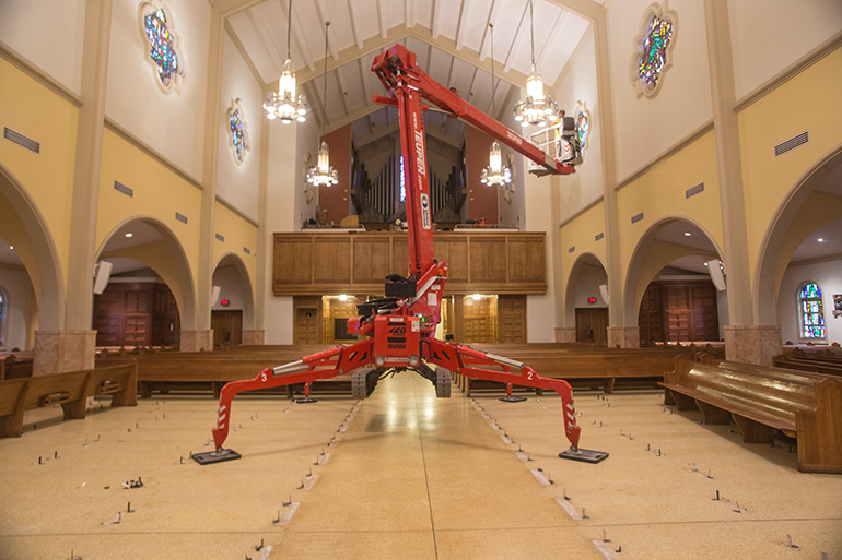 Teupen Leo series aerial spider lift occupies the space where the front pews in the cathedral's main aisle were removed.